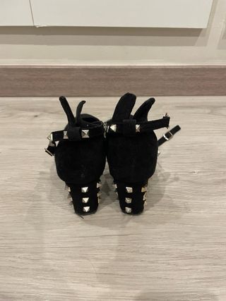 Zapatos de tacón beige y negros con diamantes.