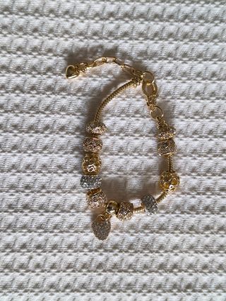 Pulsera dorada con charms plateados