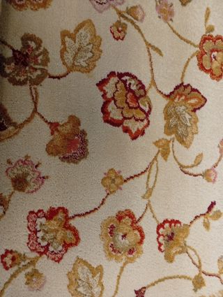 Alfombra de lana beige y roja con diseño floral