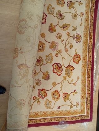 Alfombra de lana beige y roja con diseño floral