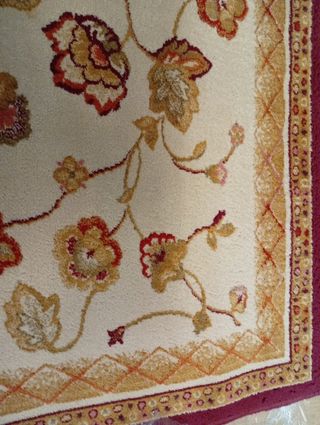 Alfombra de lana beige y roja con diseño floral