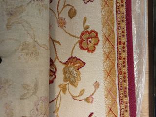 Alfombra de lana beige y roja con diseño floral