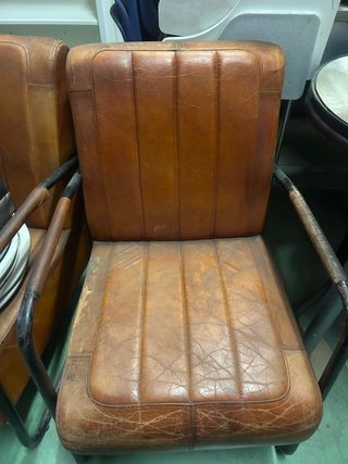 Sillón de piel marrón con brazos de hierro 