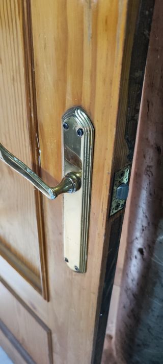 Puerta de madera con manilla dorada
