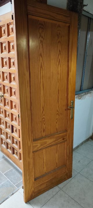 Puerta de madera con manilla dorada