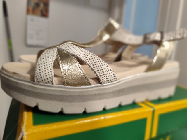 Sandalias doradas y blancas