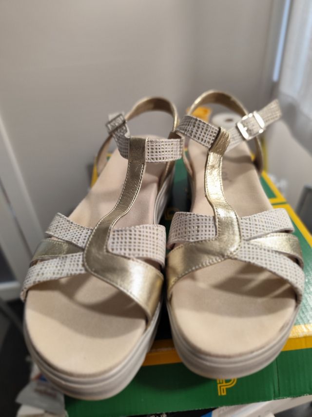 Sandalias doradas y blancas