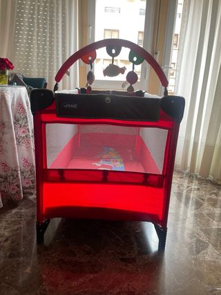 Cuna de viaje roja y gris de Jané. 
