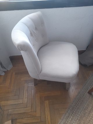 Sillón tapizado beige con patas de madera 