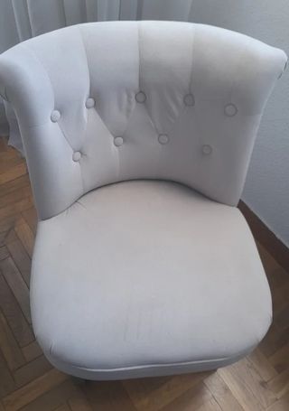Sillón tapizado beige con patas de madera 