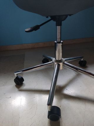 Silla de oficina gris y plateada giratoria.