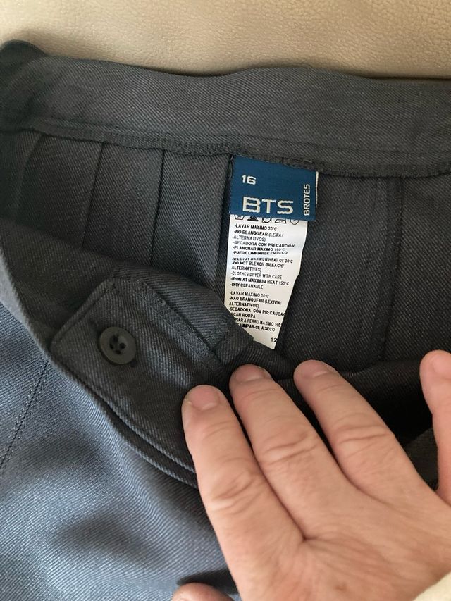 Falda plisada gris con hebillas.