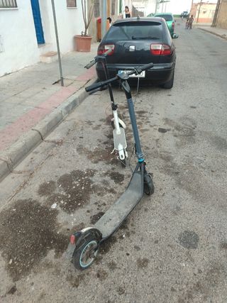 Patinete eléctrico gris e uno blanco