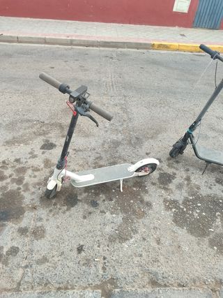 Patinete eléctrico gris e uno blanco