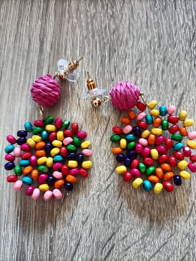Pendientes multicolor con bolitas rosas.