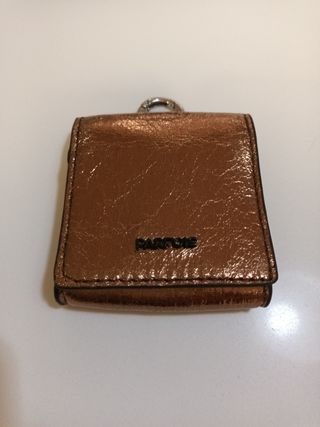 Cartera Parfois dorada con anilla para colgar.