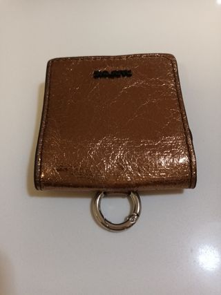 Cartera Parfois dorada con anilla para colgar.