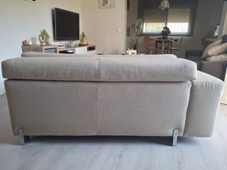 Sofá de tela beige con patas metálicas