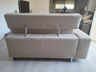 Sofá de tela beige con patas metálicas