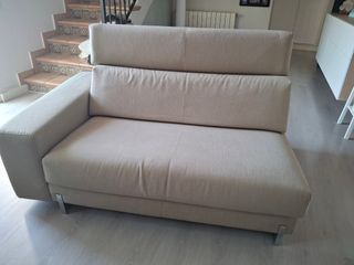 Sofá de tela beige con patas metálicas
