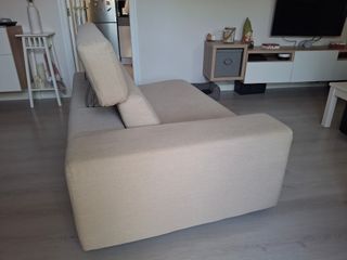 Sofá de tela beige con patas metálicas