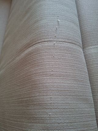 Sofá de tela beige con patas metálicas