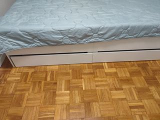 Cama blanca con cajones de madera