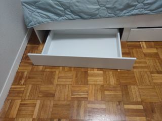 Cama blanca con cajones de madera