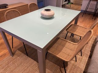 Mesa de comedor extensible de cristal y metal.