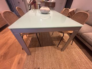 Mesa de comedor extensible de cristal y metal.
