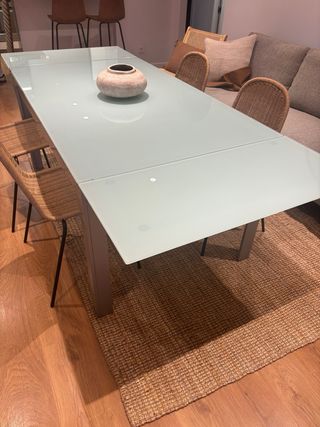 Mesa de comedor extensible de cristal y metal.