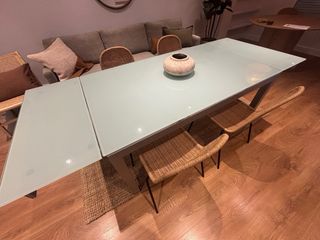 Mesa de comedor extensible de cristal y metal.