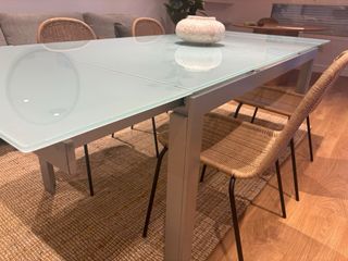 Mesa de comedor extensible de cristal y metal.