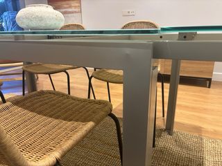 Mesa de comedor extensible de cristal y metal.