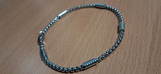 Pulsera de acero inoxidable en tono plateado.