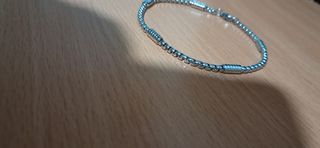 Pulsera de acero inoxidable en tono plateado.