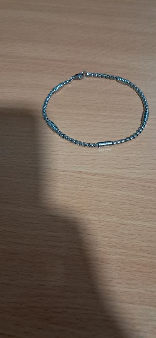 Pulsera de acero inoxidable en tono plateado.
