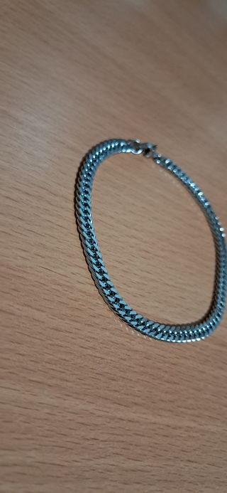 Pulsera de acero inoxidable en tono plateado.