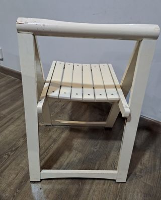 Silla de madera blanca plegable.