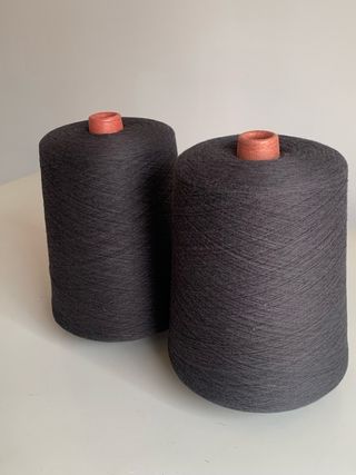 Dos conos de hilatura gris oscuro