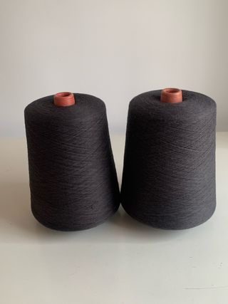 Dos conos de hilatura gris oscuro