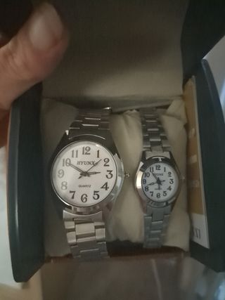 Pareja de relojes HYUNX plateados y blancos.