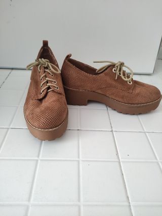 Zapatos marrones con cordones y suela gruesa