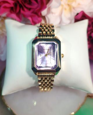Reloj de pulsera dorado con esfera lila
