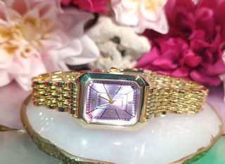 Reloj de pulsera dorado con esfera lila