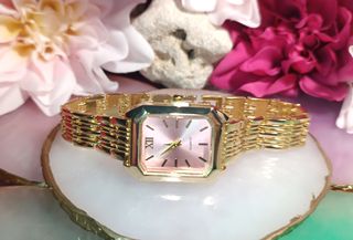 Reloj dorado con esfera rosa