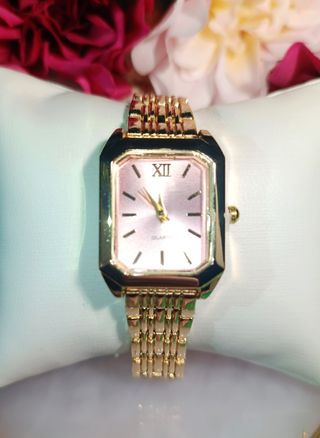 Reloj dorado con esfera rosa