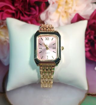 Reloj dorado con esfera rosa