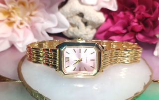 Reloj dorado con esfera rosa