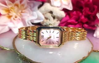 Reloj dorado con esfera rosa